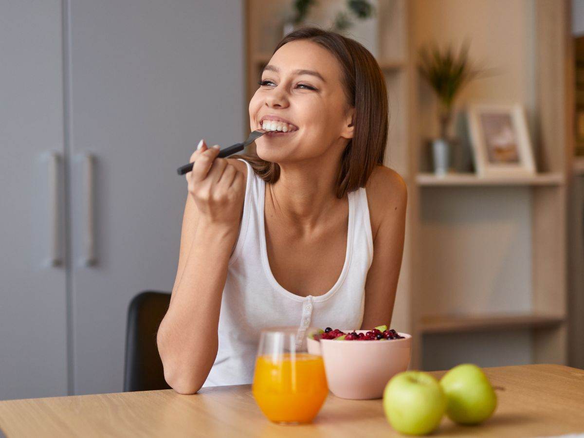 donna sorridente mangia da una ciotola