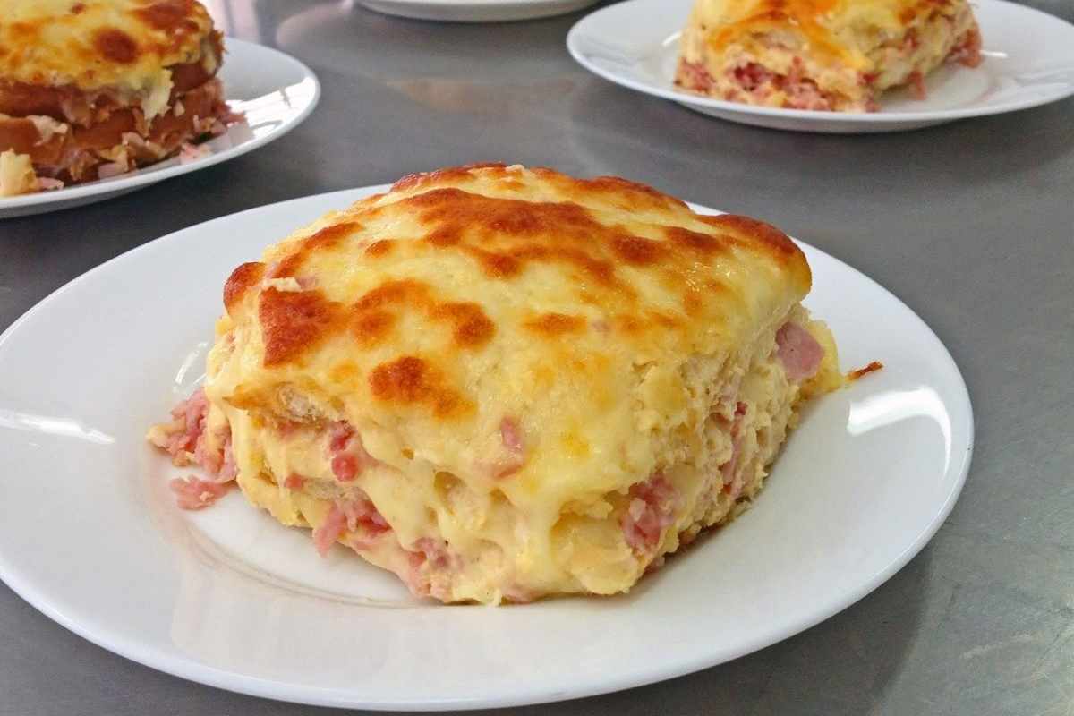 porzione di lasagna con mozzarella e prosciutto