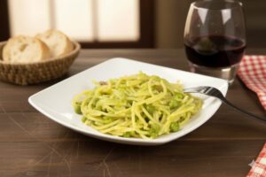 un piatto di pasta e piselli con vino e pane